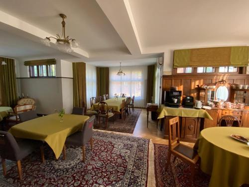 a dining room with tables and chairs and a kitchen at Villa Meri in Pärnu