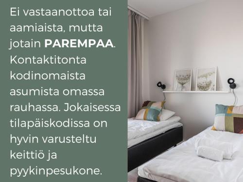 2 Betten in einem Zimmer mit Worten an der Wand in der Unterkunft Hiisi Homes Turku Fatabuurinkatu in Turku