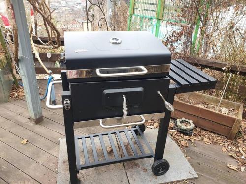 una parrilla negra sentada en un puesto en una cubierta en Gugangjae Hanok Stay, en Jeonju