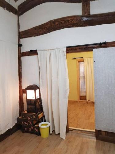 a room with a white curtain and a yellow bucket at Gugangjae Hanok Stay in Jeonju