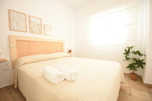 1 dormitorio blanco con 2 toallas en una cama en BITA Home en Barbate