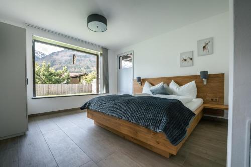 a bedroom with a bed and a large window at Landart-Appartements in Virgen