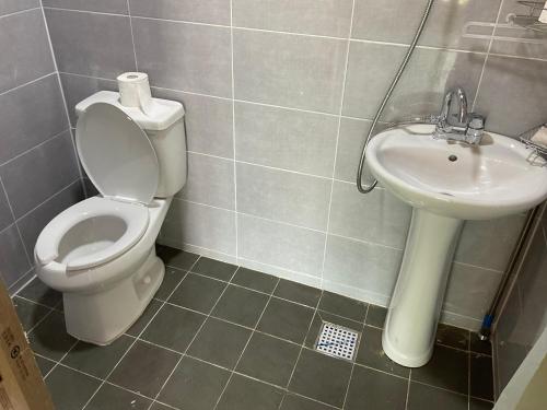 a bathroom with a toilet and a sink at Guesthouse Comfort Place in Buan