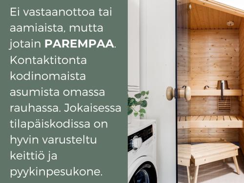 a laundry room with a washing machine and a wall with words at Hiisi Homes Tampere Muotiala in Tampere