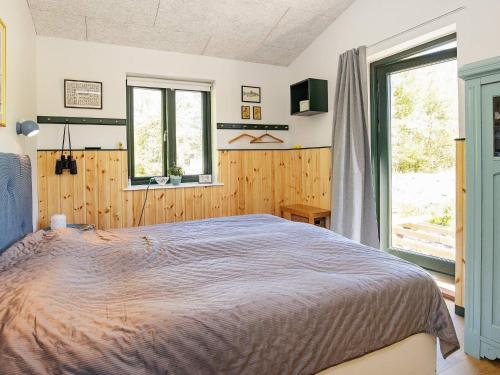 um quarto com uma cama e uma grande janela em Holiday home Sæby CXXV em Sæby
