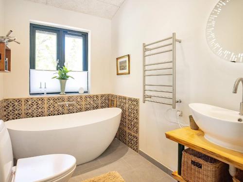 uma casa de banho com uma banheira, um WC e um lavatório. em Holiday home Sæby CXXV em Sæby