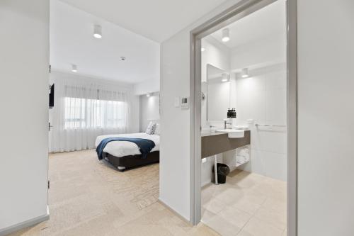 a bedroom with a bed and a sink and a mirror at Lithgow Workies Club Motel in Lithgow
