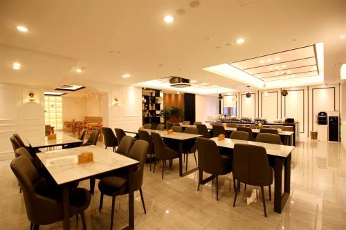 a restaurant with tables and chairs in a room at Seattle B Hotel in Busan