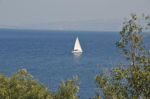 un velero en medio de un gran cuerpo de agua en PaxosBlue Suites & Villas, en Gáios