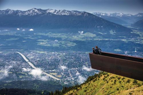 duas pessoas sentadas à beira de uma montanha em Holidayhome OMYXL em Innsbruck