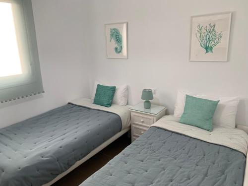 a bedroom with two twin beds and a window at Apartamento La Sirenita in Rota