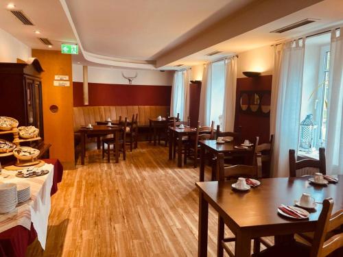 - un restaurant avec des tables et des chaises en bois dans une chambre dans l'établissement Hotel Rosenheimer Hof, à Traunstein