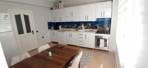 uma cozinha com armários brancos e uma mesa de madeira em 3+1 em Antalya