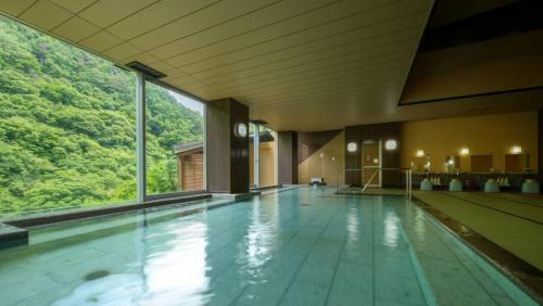 a large swimming pool with a large window in a building at Ashinomaki Grand Hotel in Aizuwakamatsu