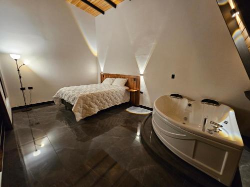 a bedroom with a bed and a bathtub and a sink at Wind Houses, Casas de Viento in Monteverde Costa Rica