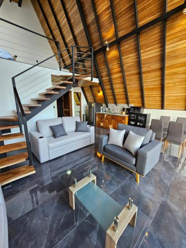 a living room with two couches and a staircase at Wind Houses, Casas de Viento in Monteverde Costa Rica
