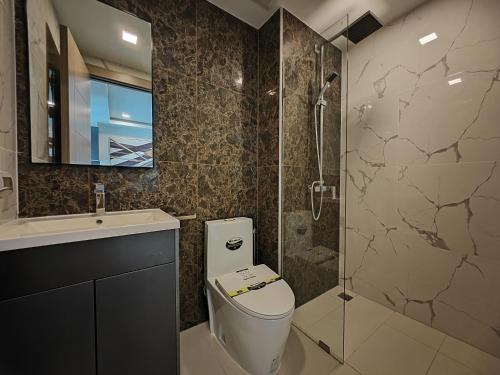 a bathroom with a toilet and a glass shower at Arcadia Beach Continen in Pattaya South