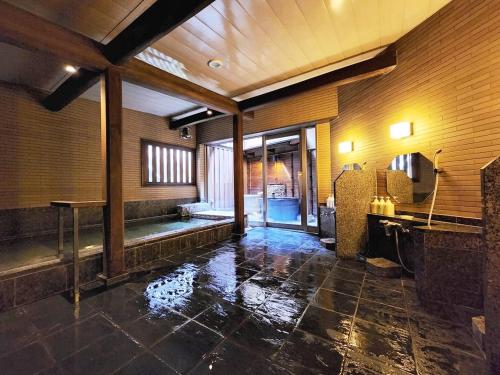 bagno con vasca e lavandino in camera di Ryokan Tanabe 旅館 田邊 a Takayama