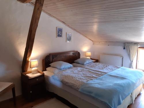 アルティガにあるFerme Beauregard Les Pyrénéesのベッドルーム1室(青いシーツとランプ2つ付)