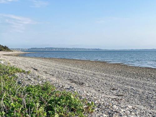 a rocky beach with the ocean in the background at 6 person holiday home in Thyholm-By Traum in Thyholm