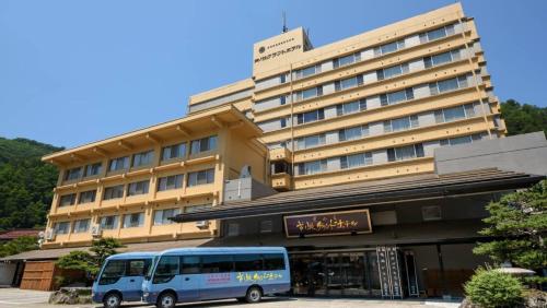 a blue bus parked in front of a building at Ashinomaki Grand Hotel in Aizuwakamatsu