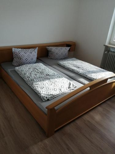a bed with a wooden frame and pillows on it at Wohnung Martha in Bayerisch Eisenstein