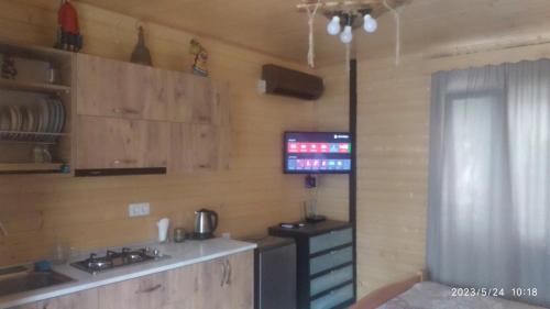 a kitchen with a stove and a tv on the wall at Cottage house in Keda