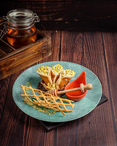 a blue plate with food on a wooden table at Holiday Inn Dhaka City Centre by IHG in Dhaka