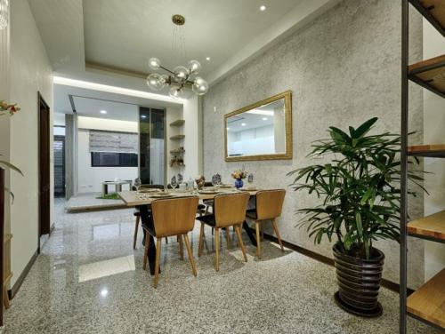 uma sala de jantar com uma mesa e um vaso de plantas em K&B Happy Villa em Tainan