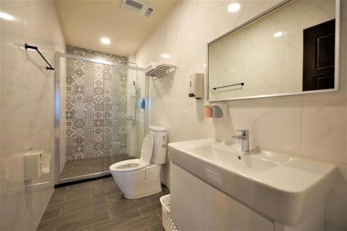 uma casa de banho com um lavatório, um WC e um chuveiro em K&B Happy Villa em Tainan