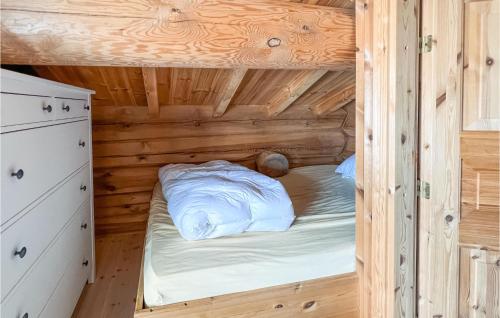 a bedroom in a log cabin with a bed in it at Awesome Home In Rn With Jacuzzi in Ron