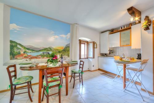 a kitchen with a table and chairs and a large window at Il Nido dell'Artista - Happy Rentals in Tenno
