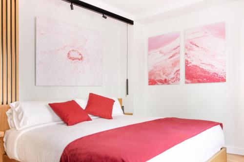 1 dormitorio con 1 cama grande con almohadas rojas en Boutique Hotel OLOM - Only Adults recommended, en Cádiz