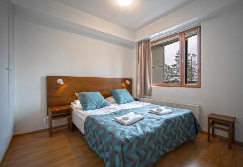 ピュハトゥントゥリにあるSki-Inn PyhäSuitesのベッドルーム1室(ベッド1台、タオル2枚付)
