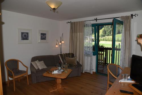 a living room with a couch and a table at Hotel LÄRCHENHOF in Kleinarl