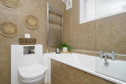 a bathroom with a toilet and a sink and a tub at Huge & Central 3 Bedr, 4 Beds, Covent Gdn in London