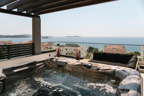 un jacuzzi en el balcón de una casa en Villa LA ZE, en Rogoznica