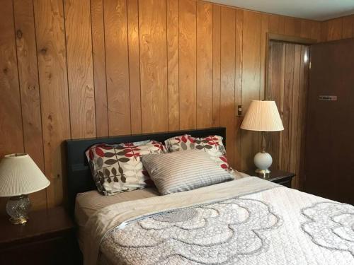 a bedroom with a bed with pillows and two lamps at A Quaint, Private 1 Bdrm Apt in South Bend