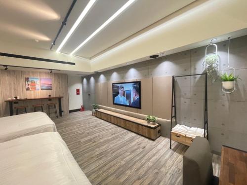 a hospital room with a bed and a flat screen tv at Soho Motel in Taoyuan