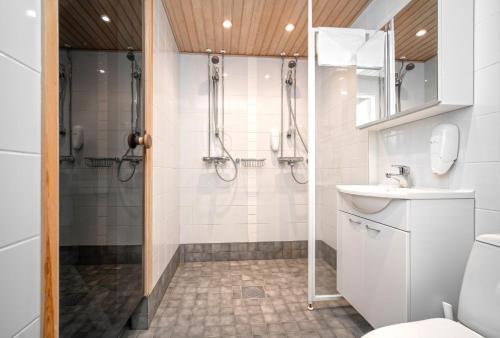 e bagno con doccia, servizi igienici e lavandino. di Ski-Inn PyhäSuites a Pyhätunturi