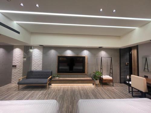 a living room with a tv and a couch at Soho Motel in Taoyuan