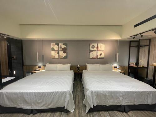 dos camas sentadas una al lado de la otra en una habitación en Soho Motel, en Taoyuan