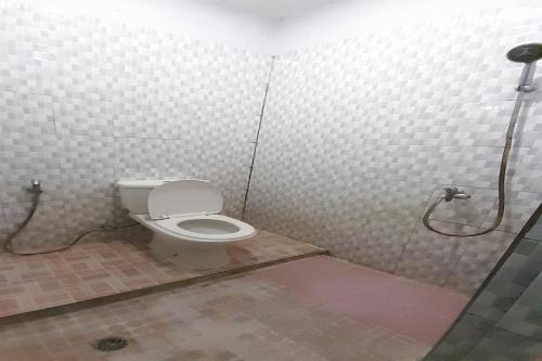 a bathroom with a toilet and a shower at OYO 92578 Sri Ulina Homestay in Medan
