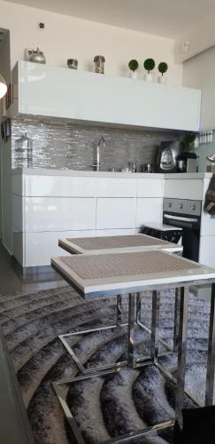 a white kitchen with a table and a sink at Mandarin hotel beach view in Jaffa Tel Aviv