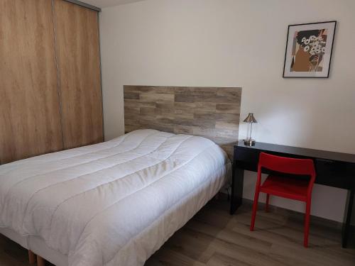 1 dormitorio con 1 cama y 1 silla roja junto a un escritorio en Appartement sur Valberg dans résidence neuve proche centre, en Valberg