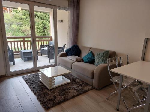 un salon avec un canapé et une table dans l'établissement Appartement sur Valberg dans résidence neuve proche centre, à Valberg
