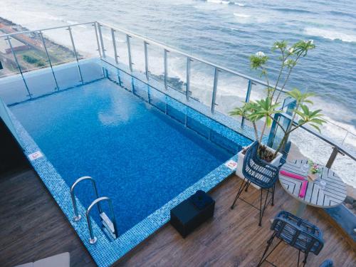 a swimming pool on a balcony with the ocean at MaRadha Colombo in Colombo