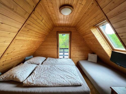 ein Schlafzimmer mit einem Bett in einem Holzhaus in der Unterkunft Chata s luxusním výhledem a bazénem in Kunčice pod Ondřejníkem