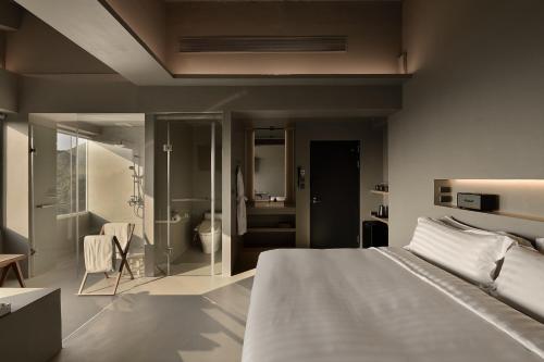 a bedroom with a bed and a bathroom at Daybreak in Jiufen