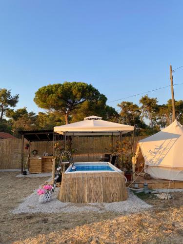 einen Pool mit Sonnenschirm und Zelt in der Unterkunft Estera Tent in Grgomičić